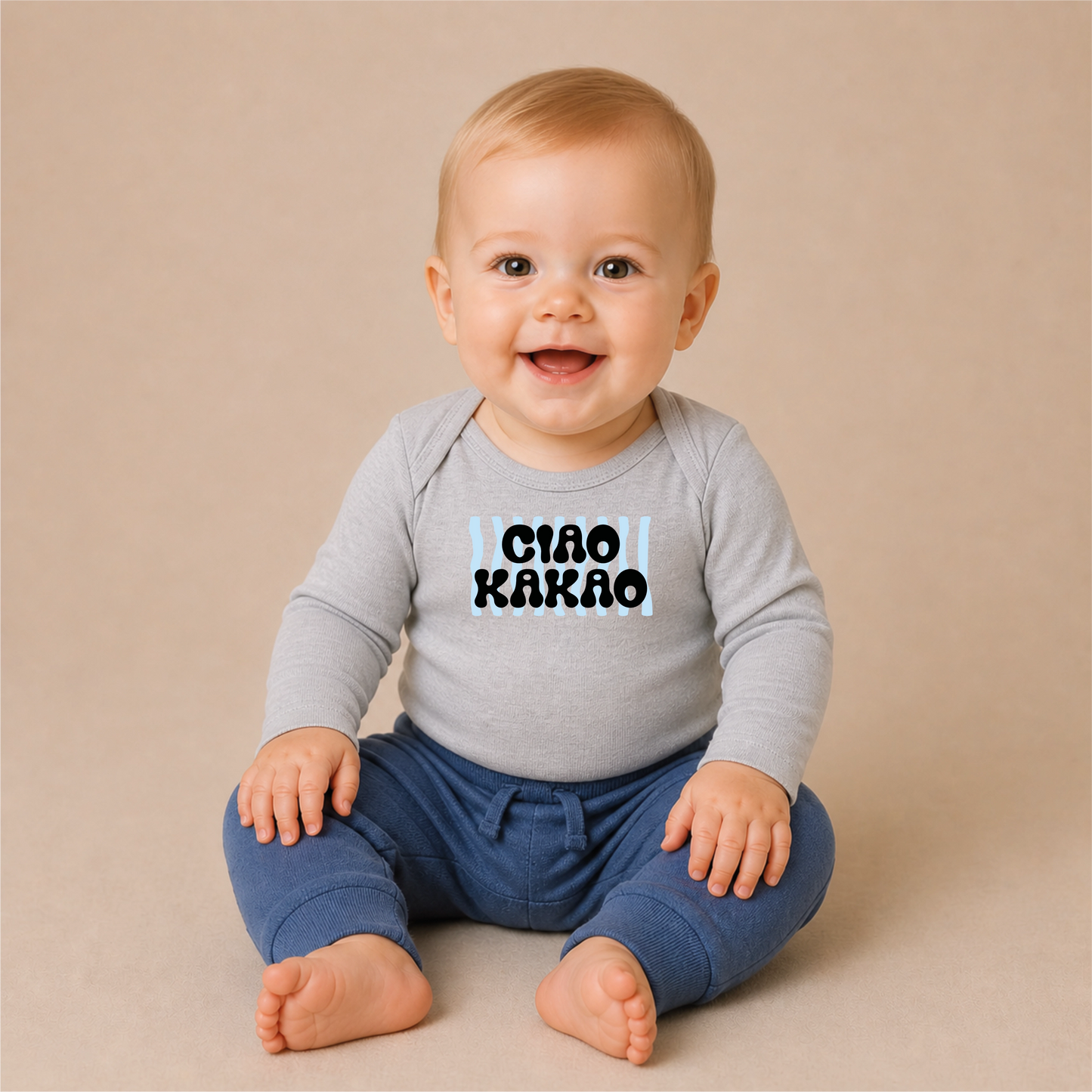 Ciao Kakao Blau schmales Bügelbild auf grauem Baby-Langarmshirt – sitzendes Baby