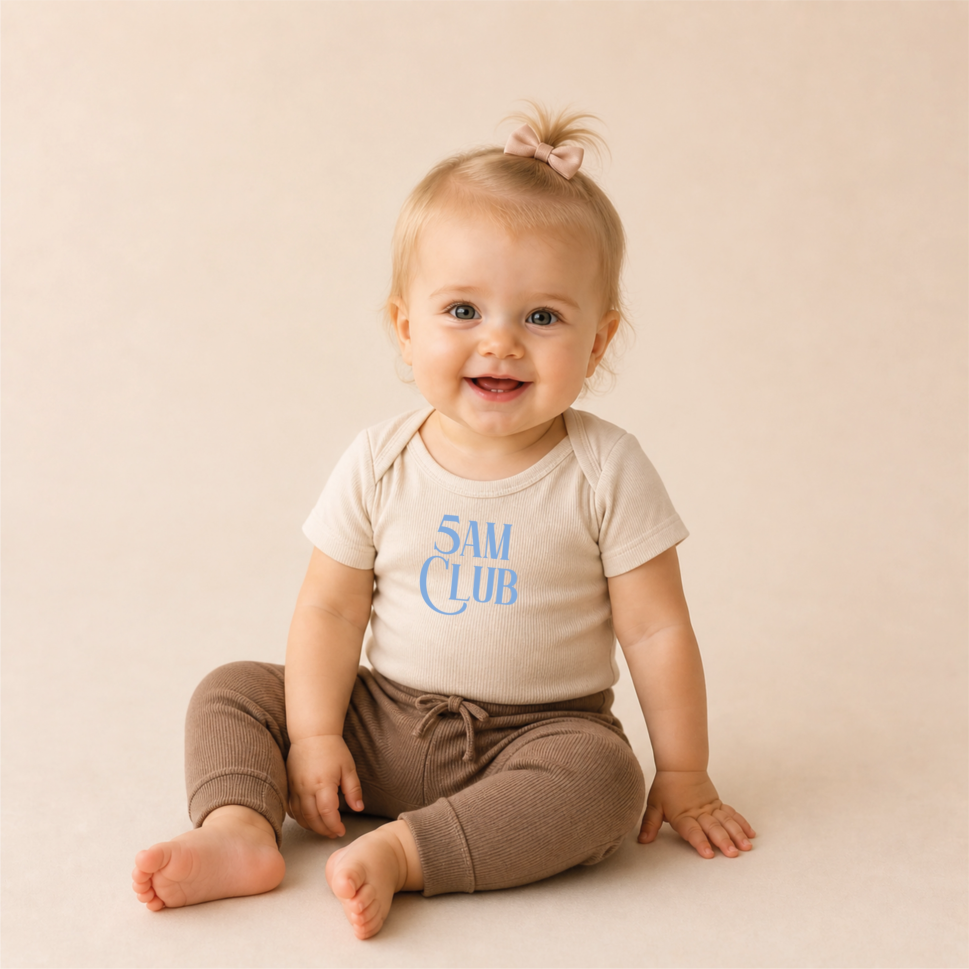 5AM Club Bügelbild auf beigem Baby-Body – sitzendes Baby